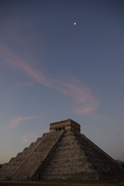 a gibbous Moon seen at dawn over the Castle of Kukulkan at Chichen Itza, Mexico.